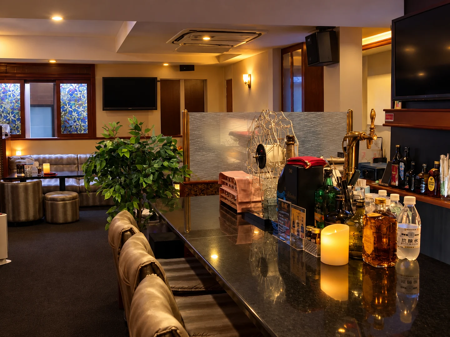 暖かな照明に包まれたBAR 4Bのカウンターと奥のソファ席